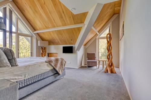 a bedroom with a large bed and large windows at Duinvilla Noordwijk in Noordwijk
