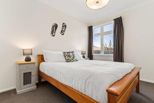 a bedroom with a large bed and a window at Sunset Villa in Martinborough