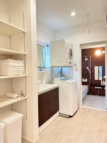 a white kitchen with a sink and a microwave at Akikawa Koshi 13 新築木造一棟貸切ヴィラ in Yuge
