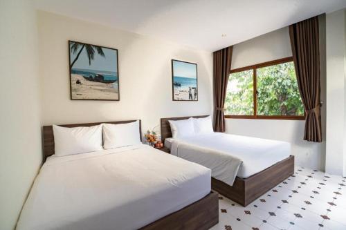 a bedroom with two beds and a window at Linh Lan Homestay in Phan Thiet