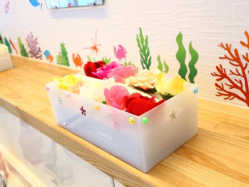 a white box filled with flowers on a table at ホステル富士山 結 in Fujiyoshida