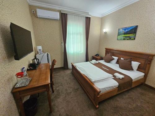 ein Hotelzimmer mit Bett und Schreibtisch in der Unterkunft Maximum Hotel in Navoiy