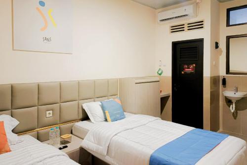 a hospital room with two beds and a sink at SANS Hotel Joy Inn Brebes in Ketanggungan