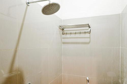 a shower with a shower head in a bathroom at SANS Hotel Joy Inn Brebes in Ketanggungan