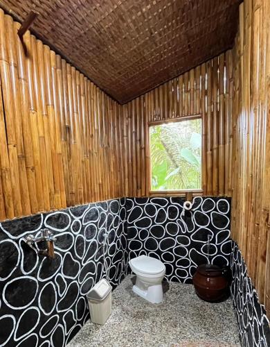 a wooden bathroom with a toilet and a window at el bamboo guesthouse in Jambu