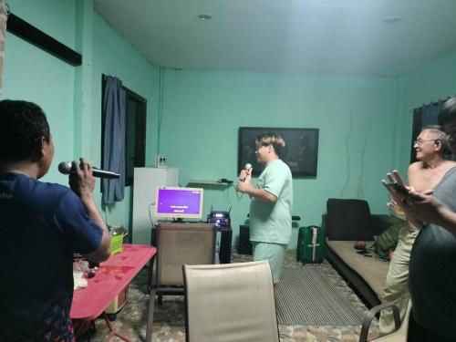 a man standing in a room with a group of people at ดงสัก สไตล์ป่า ไทรโยคน้อย in Ban Phu Pla Kang