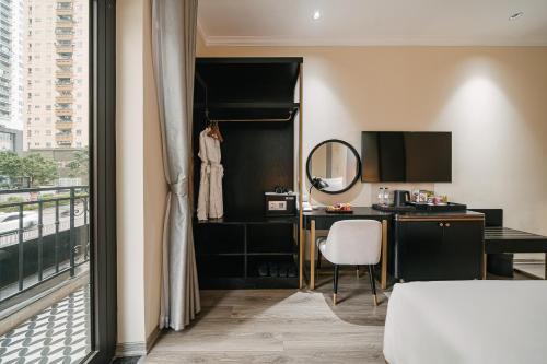 a hotel room with a desk and a mirror at Quatorze Hotel in Hanoi