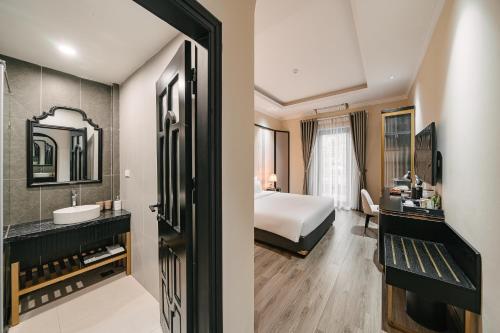 a hotel room with a bed and a bathroom at Quatorze Hotel in Hanoi