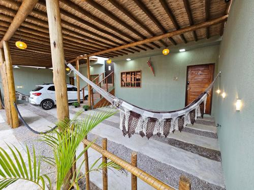 a porch with a hammock in a house at Casas Costa Dos Corais - 200m do mar, Climatizada, Confortável e Completa in Japaratinga