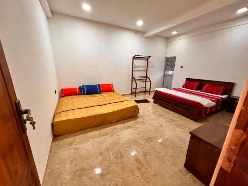 a bedroom with two beds and a chair in it at River Side Guest House in Hatton