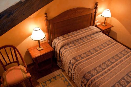 a bedroom with a bed and two lamps on tables at La Casa del Organista in Santillana del Mar
