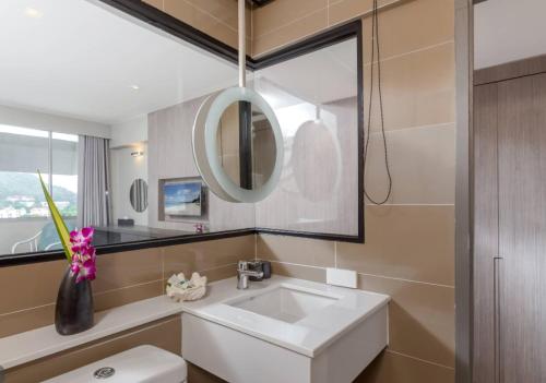 a bathroom with a white sink and a mirror at Pearl Hotel Phuket in Phuket