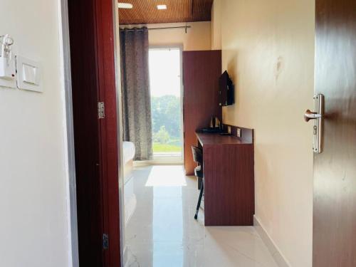 a room with a hallway with a desk and a window at The Deerfield Cottages in Rāmnagar
