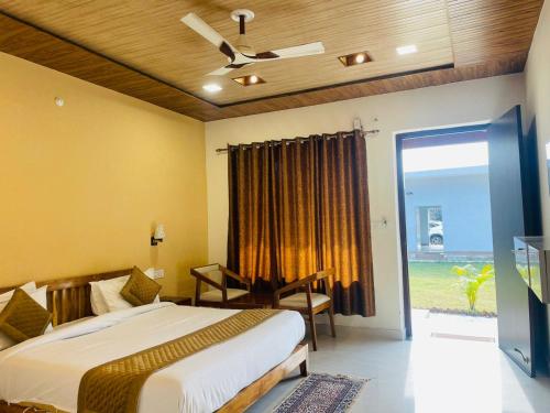 a bedroom with a bed and a sliding glass door at The Deerfield Cottages in Rāmnagar