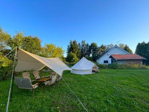 a couple of tents sitting in a field at 完全貸切コテージとカジュアルグランピング 5月中旬-9月末 バーベキュー 露天風呂 映画 お子様から祖父母まで in Kami-furano