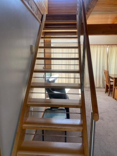 a wooden staircase in a room with a table at Beach side Waikanae Bach in Waikanae