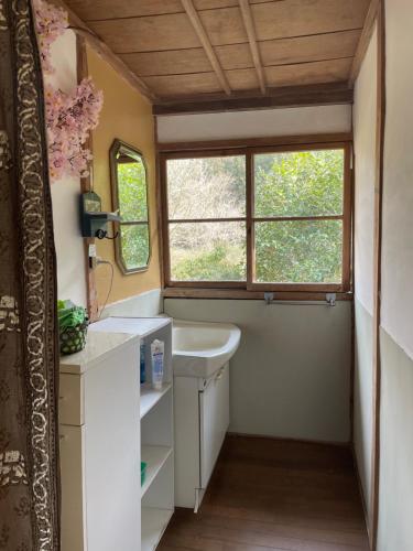 a bathroom with a sink and a window at Konosu Onsen 鴻の巣温泉 1F in Sendai
