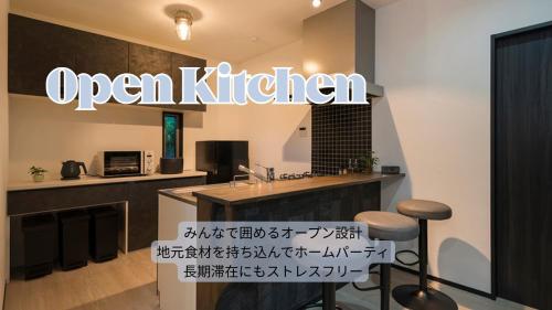 a kitchen with an open kitchen sign on the wall at Garage Base TATEYAMA in Tateyama