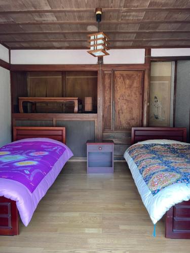 a bedroom with two beds and a chandelier at Konosu Onsen 鴻の巣温泉 1F in Sendai
