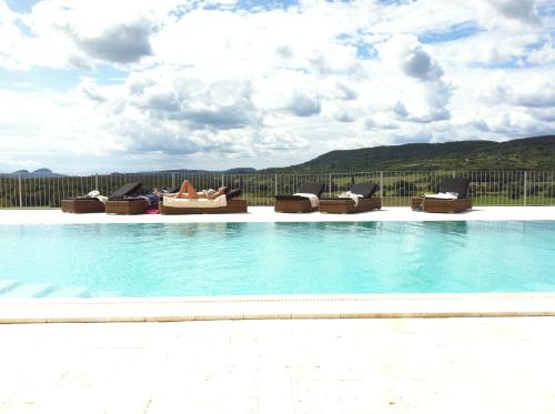 a swimming pool with lounge chairs and a view at Liszkay Borkúria in Monoszló
