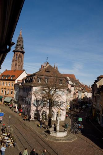 an old building in a city with a clock tower at Zum Roten Bären in Freiburg im Breisgau