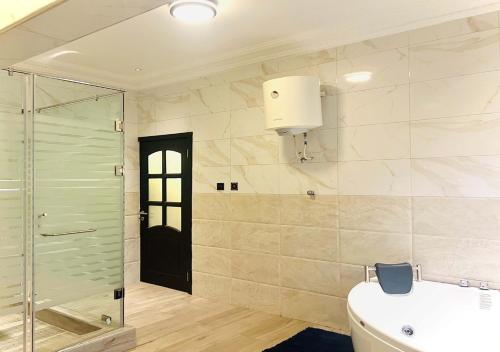 un bagno con doccia in vetro e lavandino di 3R Haven a Kumasi