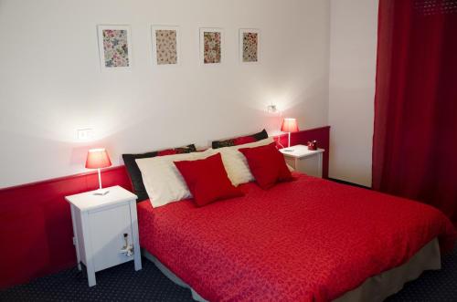 ヴァル・ディ・ゾルドにあるAlbergo al Soleのベッドルーム1室(赤いベッド1台、ナイトスタンド2台付)
