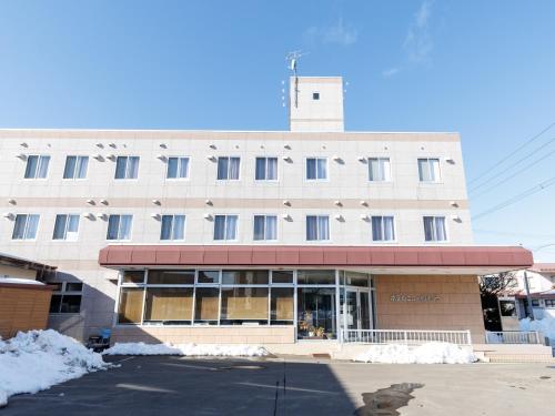 a large building with snow in front of it at Tabist Hotel New Nemuro in Nemuro