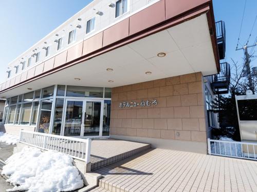 a building with a bench in front of it at Tabist Hotel New Nemuro in Nemuro