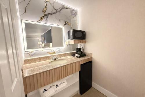 a bathroom with a sink and a mirror at The Aventis Inn in Somers Point
