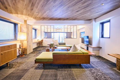 a bedroom with two beds and a living room at Hotel Vintage Tokyo Kagurazaka in Tokyo