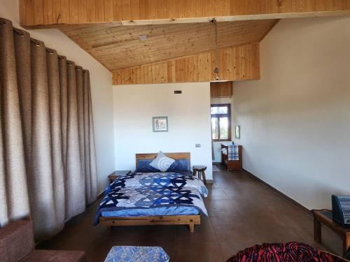 a bedroom with two beds in a room with wooden ceilings at Mangat Farm, Kanatal in Kanatal
