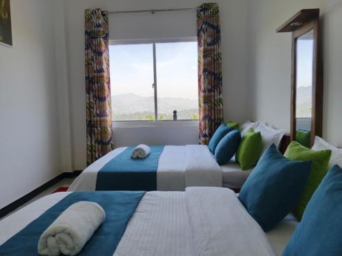 a bedroom with two beds and a large window at Roo Heaven Villas in Haputale