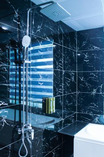 a black tiled bathroom with a shower in it at Nice's Hotel Ninh Binh in Ða Gia