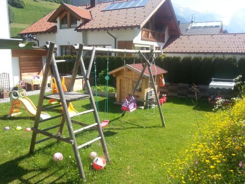 a playground in a yard with a swing at Ferienhaus Gundi in Pettneu am Arlberg