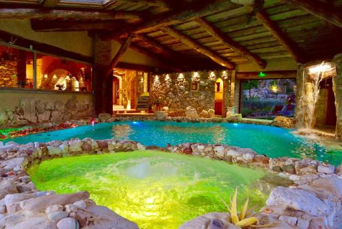 a large pool of water in a room with rocks at Luxury villa Colle dell'Asinello ,proprietari ,Villa In esclusiva near ORVIETO in Guardea