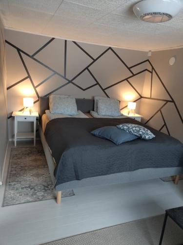 a bedroom with a bed with a geometric wall at Lakeview apartment, Espoo in Espoo