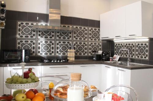 a kitchen with a table with a bowl of fruit at - Home Sweet Langhe - Room 51 in Alba