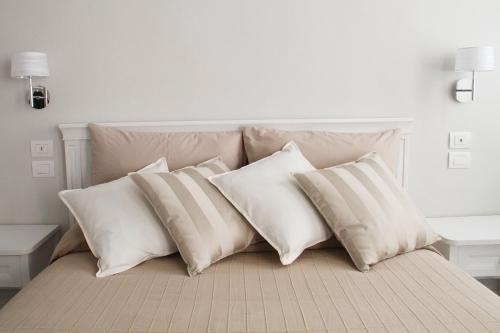 a pile of pillows on a bed in a room at - Home Sweet Langhe - Room 51 in Alba