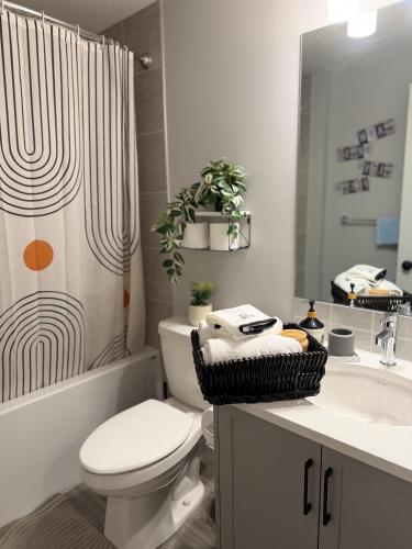 a bathroom with a toilet and a shower curtain at Relax, Recharge, Repeat 2Bedroom Walkout Haven in Calgary