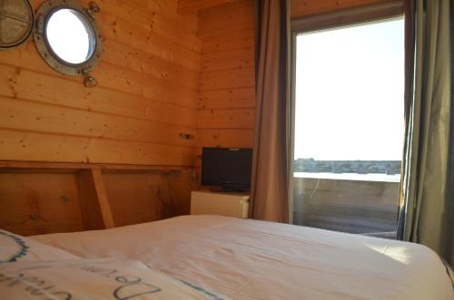 - une chambre avec un lit, une fenêtre et une télévision dans l'établissement Different Holidays, à Saumur