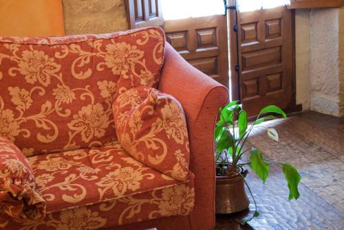 a couch sitting in a room with a plant at La Casa del Organista in Santillana del Mar