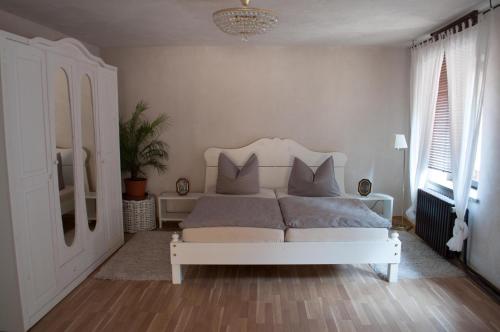 um quarto com uma cama branca com almofadas em Apartment Edelweiß em Egsdorf