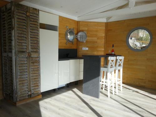 uma cozinha com paredes de madeira e um balcão com bancos em Different Holidays em Saumur