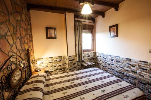 a room with a bed with a stone wall at Alojamientos Rurales Benarum con Spa in Alpujarra De La Sierra