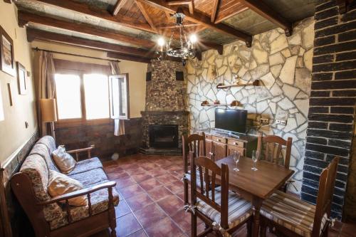 a living room with a table and a fireplace at Alojamientos Rurales Benarum con Spa in Alpujarra De La Sierra