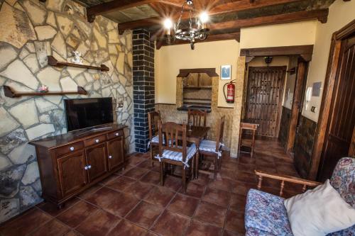 a living room with a tv and a dining room at Alojamientos Rurales Benarum con Spa in Alpujarra De La Sierra