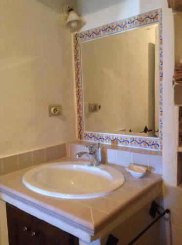 a bathroom with a sink and a large mirror at La Casa di Via Lungomare in Santa Marina Salina