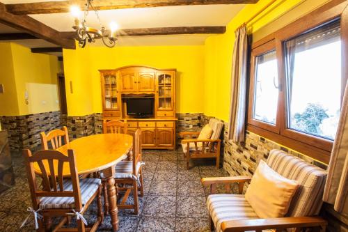 a living room with yellow walls and a table and chairs at Alojamientos Rurales Benarum con Spa in Alpujarra De La Sierra