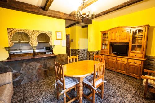 a dining room with yellow walls and a wooden table at Alojamientos Rurales Benarum con Spa in Alpujarra De La Sierra